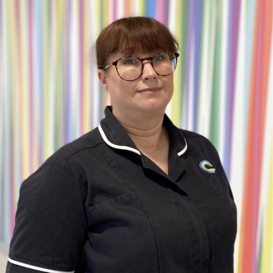 Sarah is wearing a navy nurses uniform