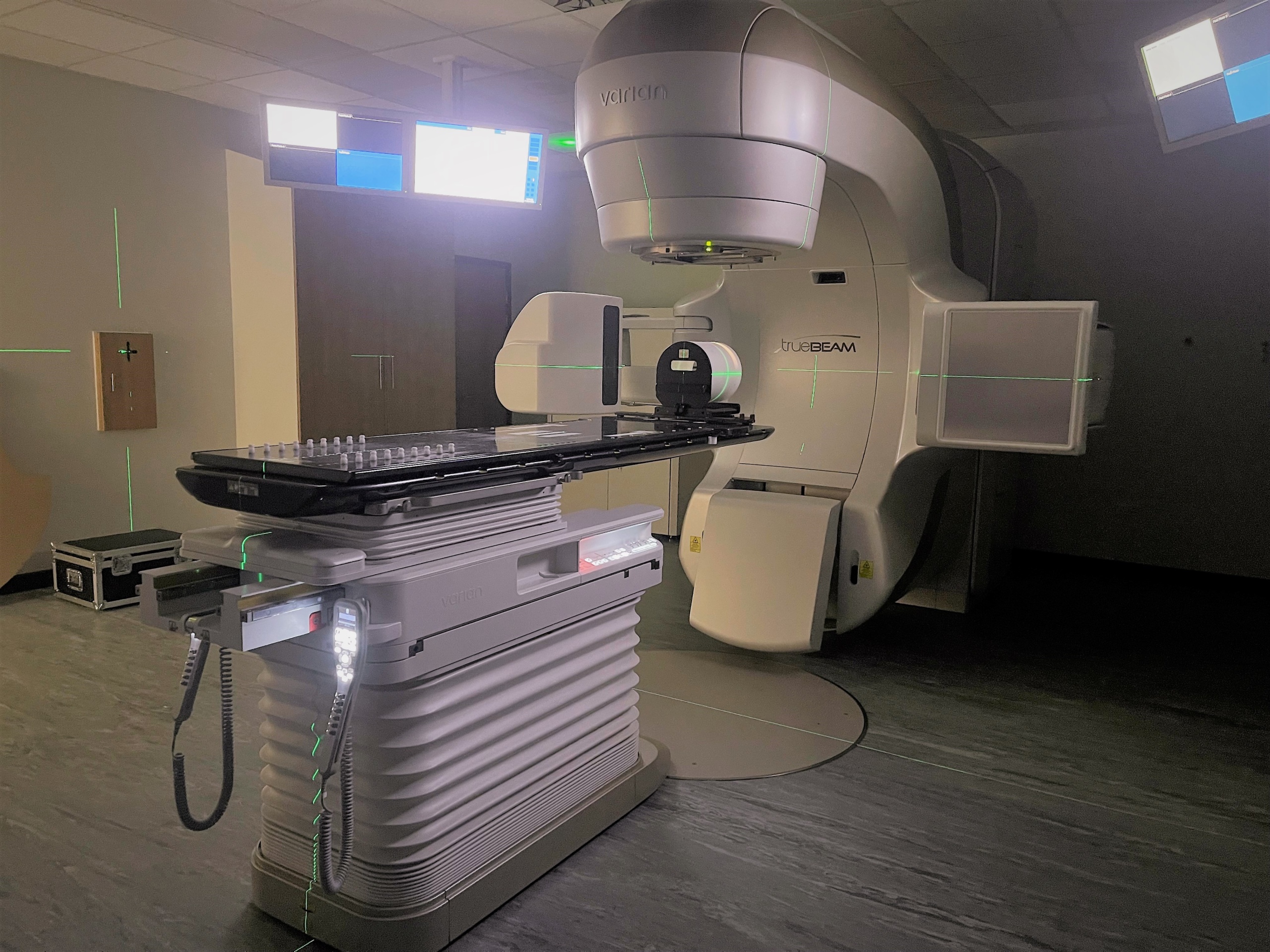 Radiotherapy treatmnt machine - known as linear accelerator or 'linac'. There is a flat table and a large arm that rotates around the table to deliver treatment