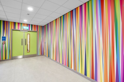 Hospital waiting area with brightly coloured artwork featuring stripes of different colours from floor to ceiling ©Rob Battersby