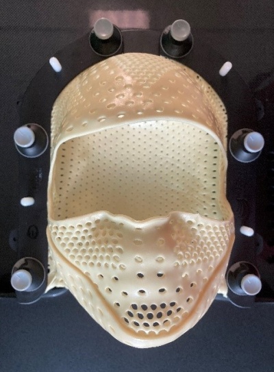 Side view of the thermoplastic mask, with perforated holes so you can breathe during treatment